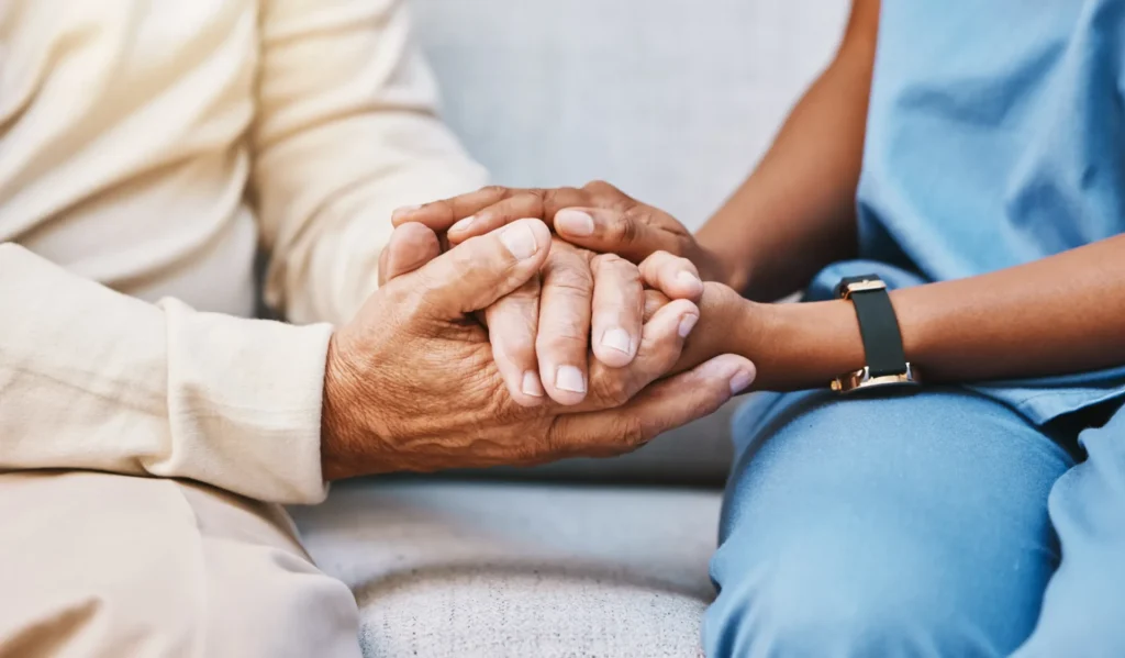 A carer holding an older person's hands